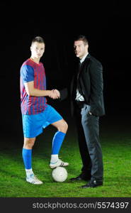 soccer sport manager in business suit coach and football player on stadium with green grass and white ball