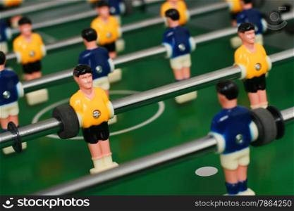 Soccer table game with yellow and blue players.