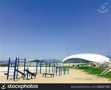 Sochi/Russia - August 2019: Playground on the beach of Adler city and Shayba Arena on the background
