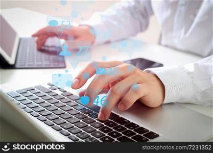 Social media and Marketing virtual icons screen concept.close up of businessman typing digital tablet with keyboard and laptop computer on white desk in modern office