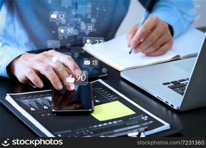Social media and Marketing virtual icons screen concept.businessman working with smart phone and digital tablet and laptop computer on wooden desk in modern office