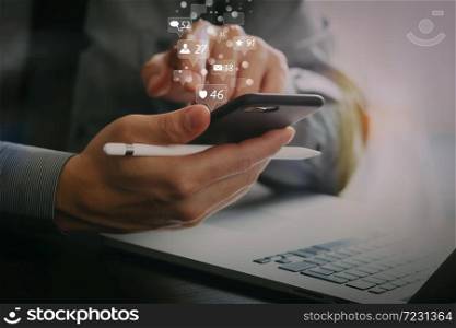 Social media and Marketing virtual icons screen concept.businessman working with mobile phone and stylus pen and laptop computer on wooden desk in modern office