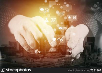 Social media and Marketing virtual icons screen concept. businessman hand working with mobile phone in modern office with city exposure