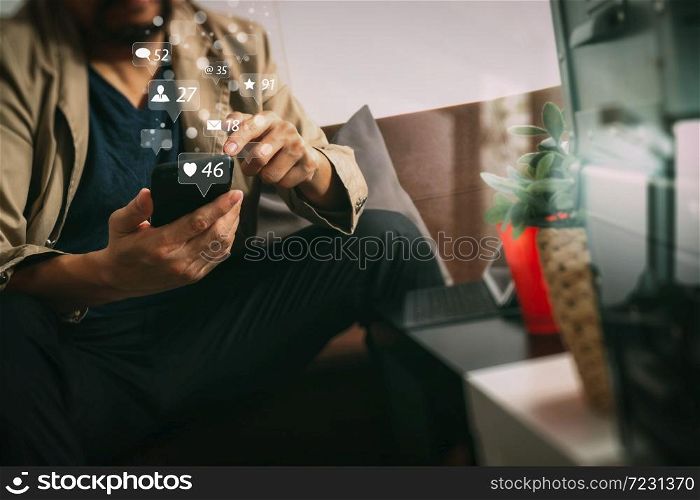 Social media and Marketing virtual icons screen concept.hipster hand using smart phone,digital tablet docking keyboard,coffee cup, payments online business,sitting on sofa in living room,work at home concept