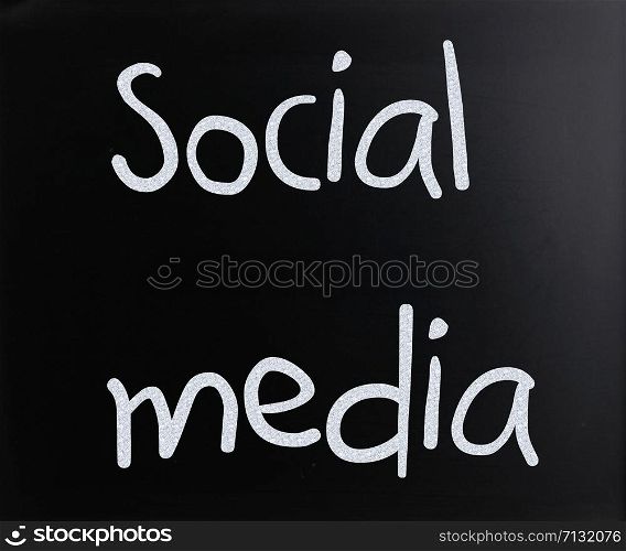 ""Social media" handwritten with white chalk on a blackboard"