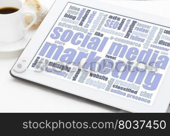 social media marketing concept - a word cloud on a digital tablet with a cup of coffee