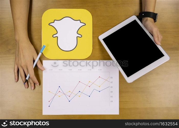 social media planner analyzing snapchat graph with digital tablet