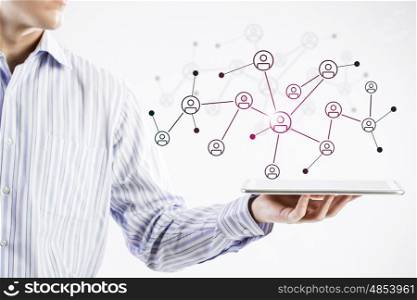 Social network structure as concept. Close view of businessman holding tablet presenting social network concept