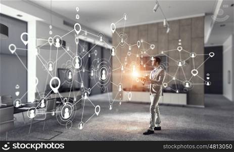 Social networking technologies. Businessman in office interior and social net connection 3D illustration