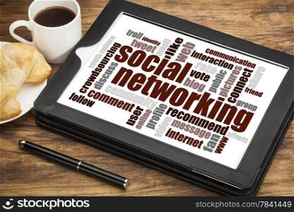 social networking word cloud on a digital tablet with a cup of coffee