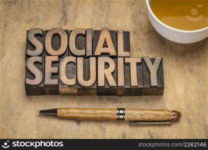 social security - word abstract in vintage letterpress wood type with a cup of tea and stylish pen, retirement and lifestyle concept