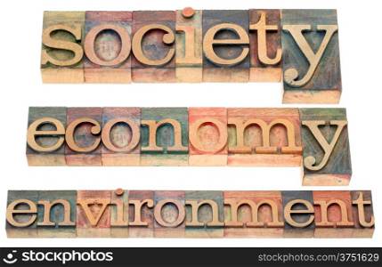society, economy, environment -a collage of isolated text in letterpress wood type printing blocks stained by color inks
