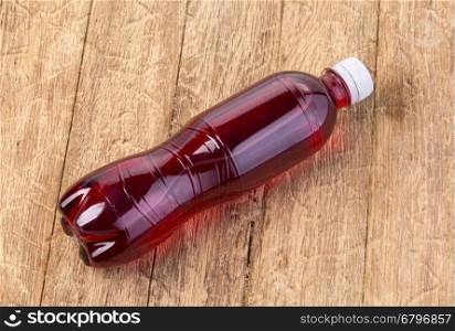 Soda bottle on the wooden table, top view