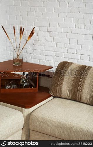 Sofa and little table on a background of a brick wall