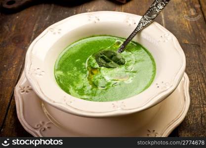 Soft and delicious spinach cream soup on wooden table