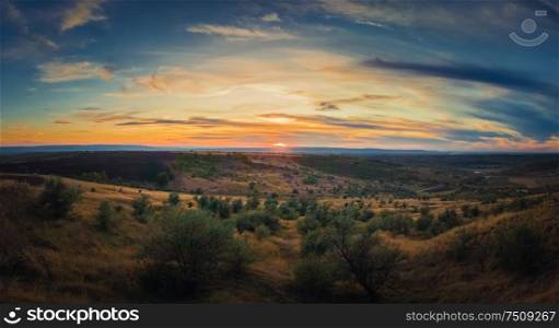 Soft autumn sunset panorama over countryside hills and valley. Beautiful rural landscape, nature scene.