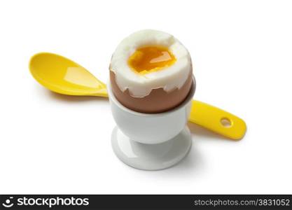 Soft boiled egg in an egg cup on white background