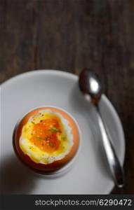 Soft boiled egg in egg cup on wooden background