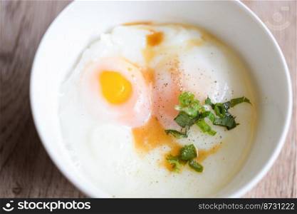 soft-boiled eggs on white bowl with pepper coriander on wooden table, egg breakfast, onsen egg