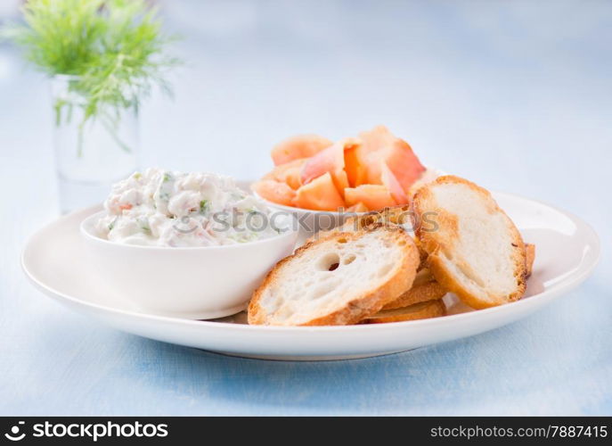 Soft cheese spread, smoked wild salmon and baguette, selective focus