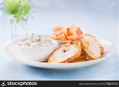 Soft cheese spread, smoked wild salmon and baguette, selective focus