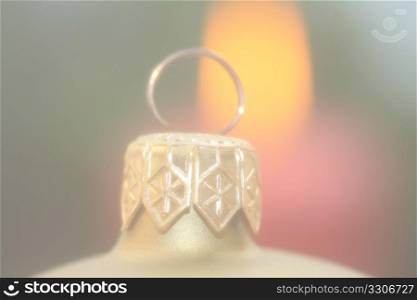 Soft focus christmas ornament, candle in background