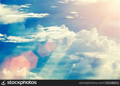Soft focus of dramatic sunset sky with clouds and flare. Vintage filtered.