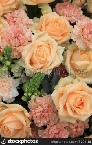 soft orange roses and carnations in a floral arrangement