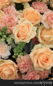 soft orange roses and carnations in a floral arrangement