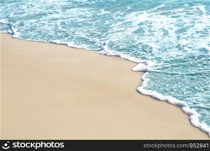 Soft wave and sea bubble of blue sea on sandy beach