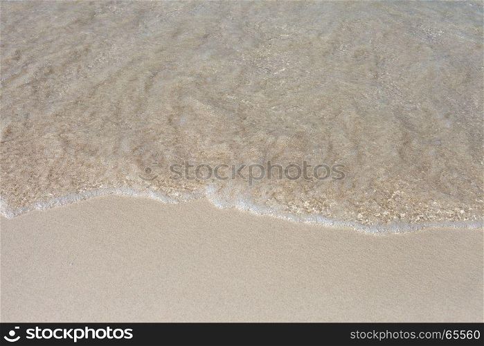 Soft Wave Of Blue Ocean On Sandy Beach. Background. Selective focus.. The Soft Wave Of Blue Ocean On Sandy Beach. Background. Selective focus.