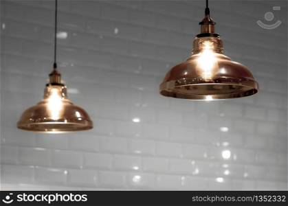 Softly focus of 2 vintage glass ceiling lamps in bronze color tone with blurred white tiles wall background in home interior decoration concept
