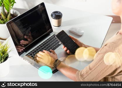 Software developer hands typing data coding programming javascript with laptop computer and mobile phone, Programmer woman looking smartphone program code at workplace, IT startup concept