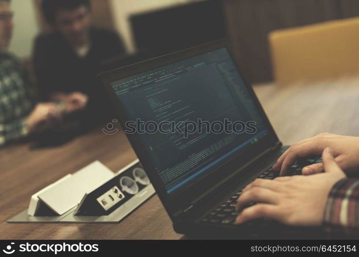 software developer writing programming code on laptop computer
