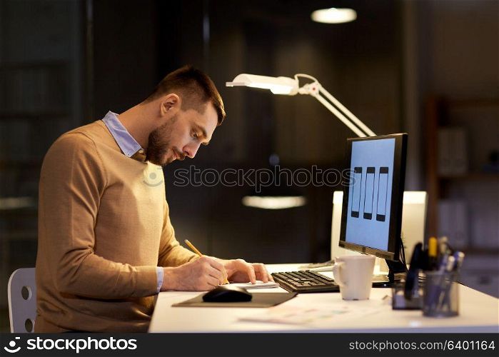 software development, business, deadline and people concept - web designer with notepad and user interface mockup on computer screen working at night office. man with notepad working at night office