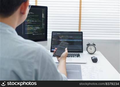 Software development concept, Male programmer check website programming on smartphone and computer.
