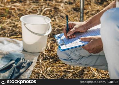 Soil Test. Female agronomist taking notes in the field. Environmental protection, organic soil certification, research