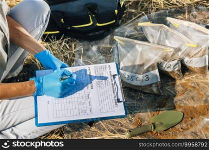 Soil Test. Female agronomist taking notes in the field. Environmental protection, organic soil certification, research