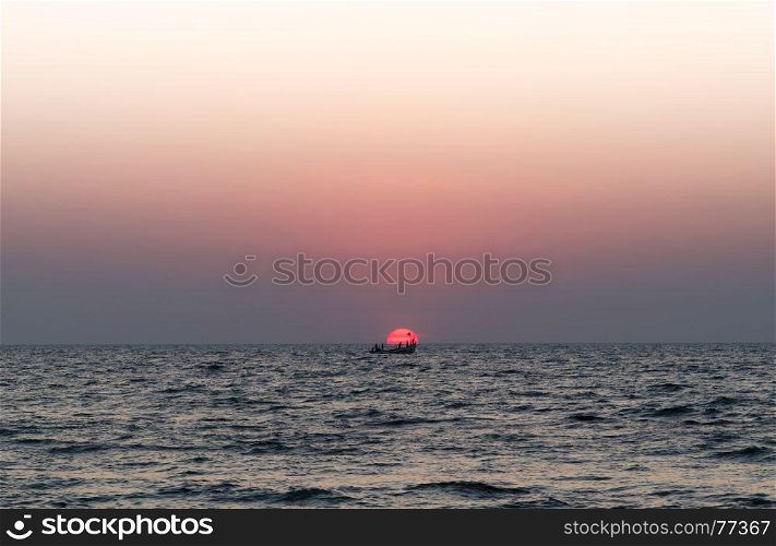 Solar disk boat people ocean sunset