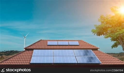 Solar panel on a roof of a house with wind turbines around. Photovoltaic, alternative electricity source. sustainable resources