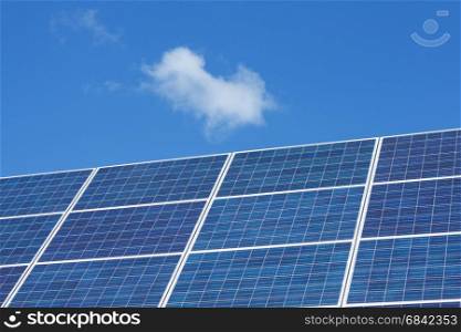 Solar panels and clouds against blue sky