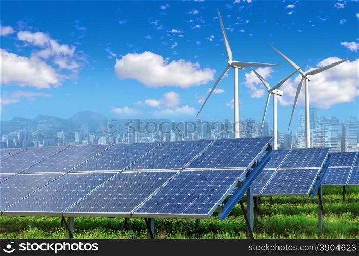solar panels and wind turbines under blue sky and clouds with city on horizon. Solar panels and wind turbines with city