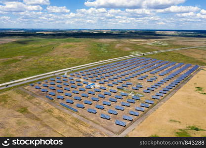 solar panels at the field with the beautiful clouds at sunny summer day aerial view