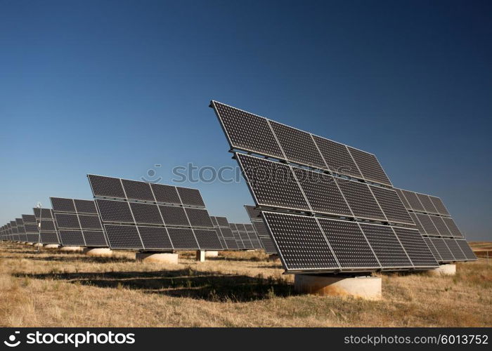 Solar panels in a greenfield, over blue sky