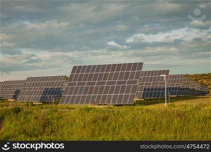 Solar panels in the landscape with a cloudy sky of background
