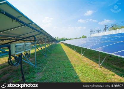Solar panels or solar cells on the roof in farm. Power plant with green field, renewable energy source in Thailand. Eco technology for electric power in industry.