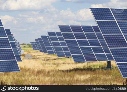 solar panels standing at the field at the bright sunny day