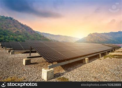 solar panels with against view of the reservoir and mountanis landscape against during sky sunset,Alternative energy concept.