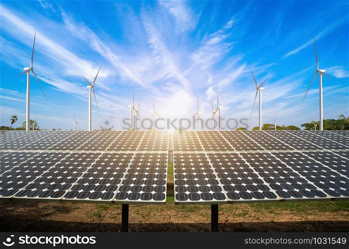 solar panels with wind turbines against mountanis landscape against blue sky with clouds,Alternative energy concept,Clean energy,Green energy.
