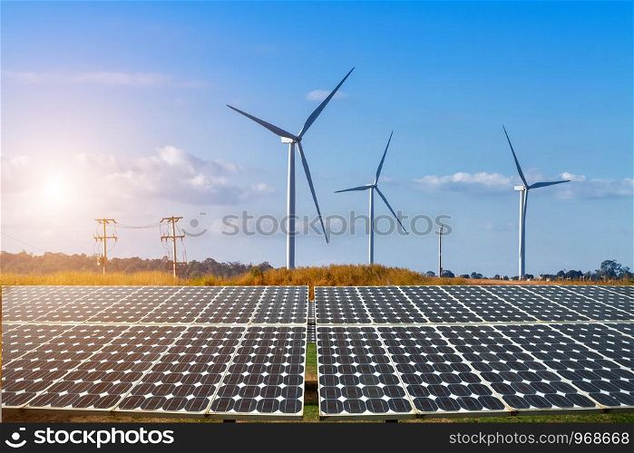 solar panels with wind turbines against mountanis landscape against blue sky with clouds,Alternative energy concept,Clean energy,Green energy.